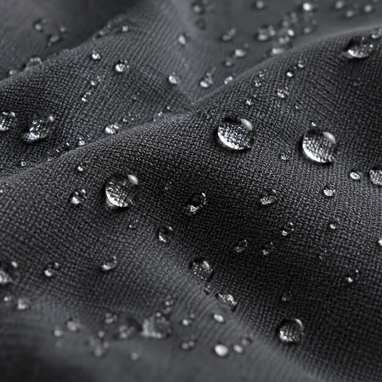 Macro de softshell gris carbón con gotas de agua sobre la superficie